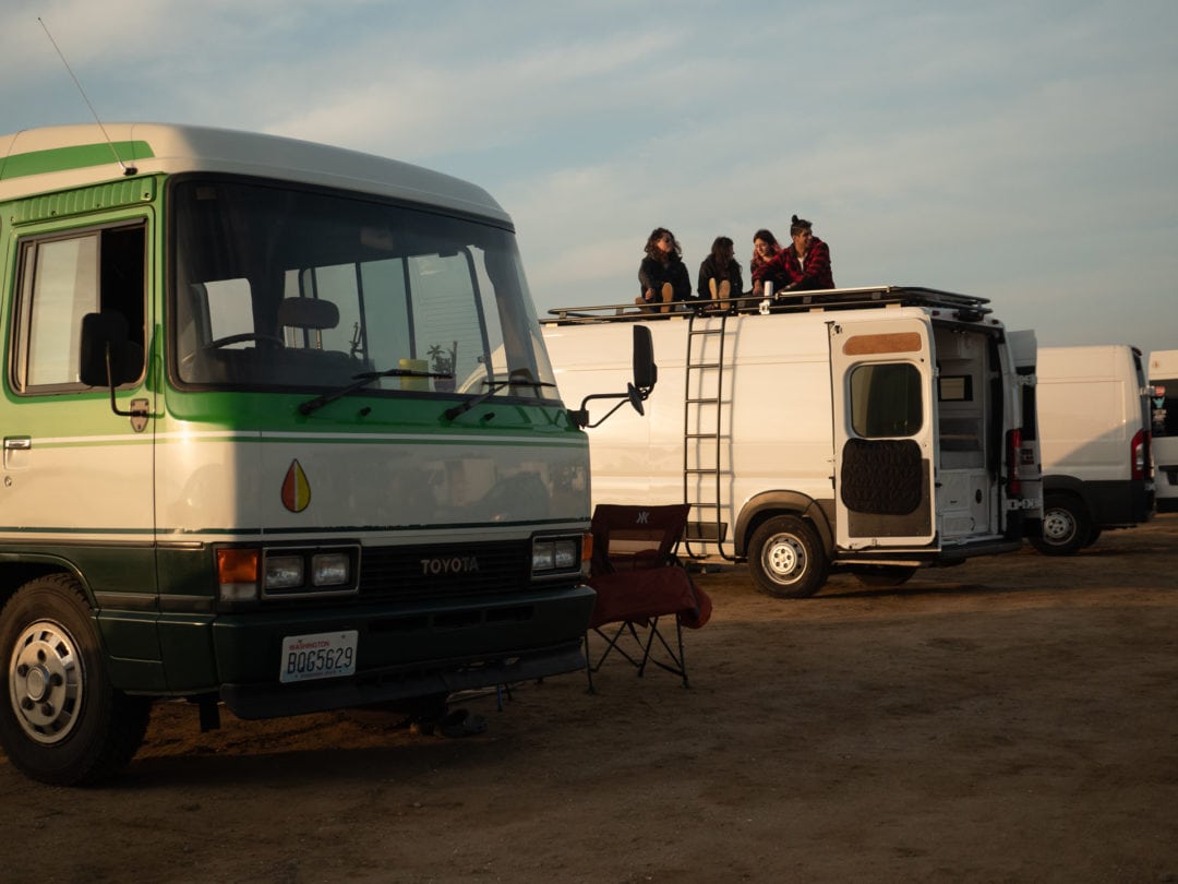Group of friends at a boondocking location sitting on top of van