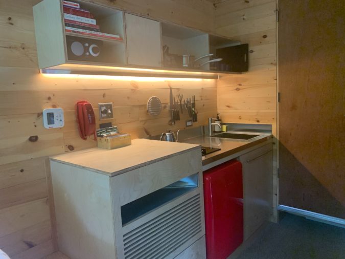 Kitchen inside a tiny house in the woods.