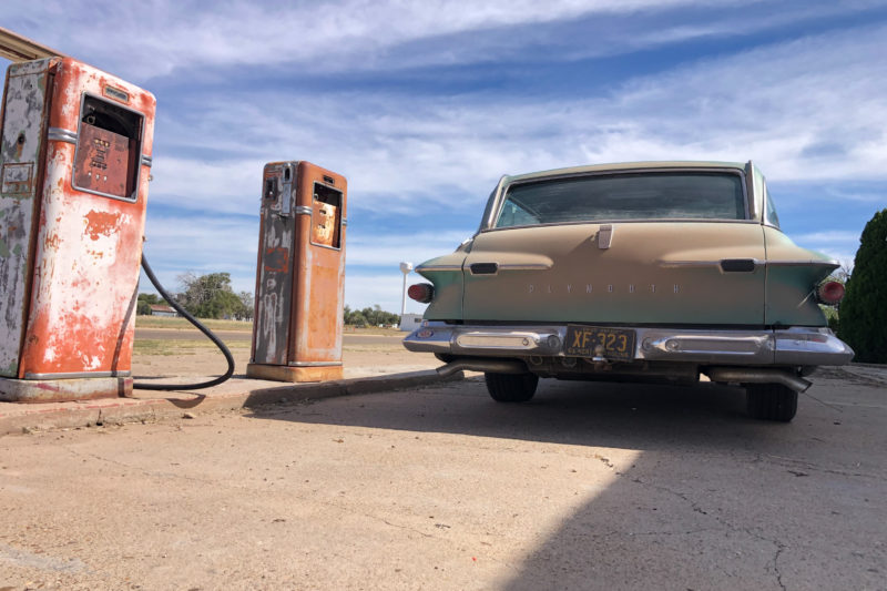 a station wagon at a vintage gas station