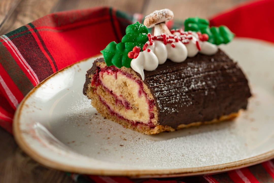 a festive log cake topped with holly berries