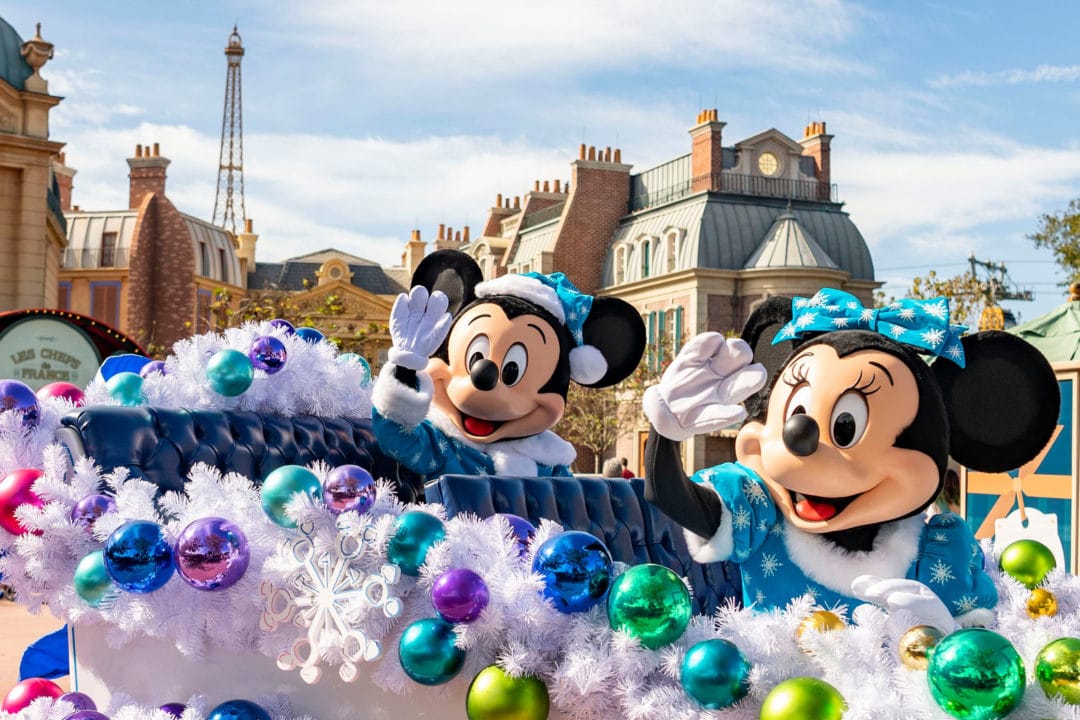 Mickey and Minnie wave from a festive float.