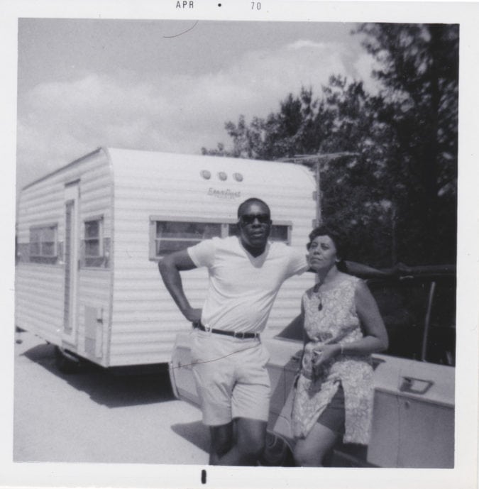 a couple stands in front of an rv in a black and white photo