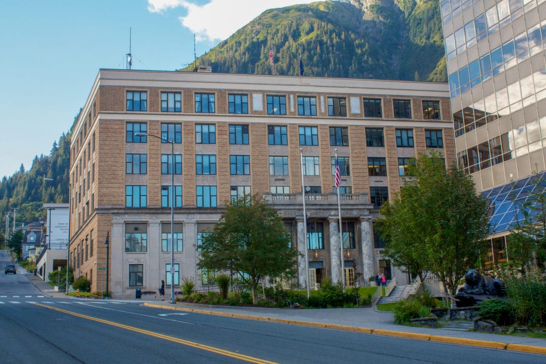 A large building with a towering mountain behind it