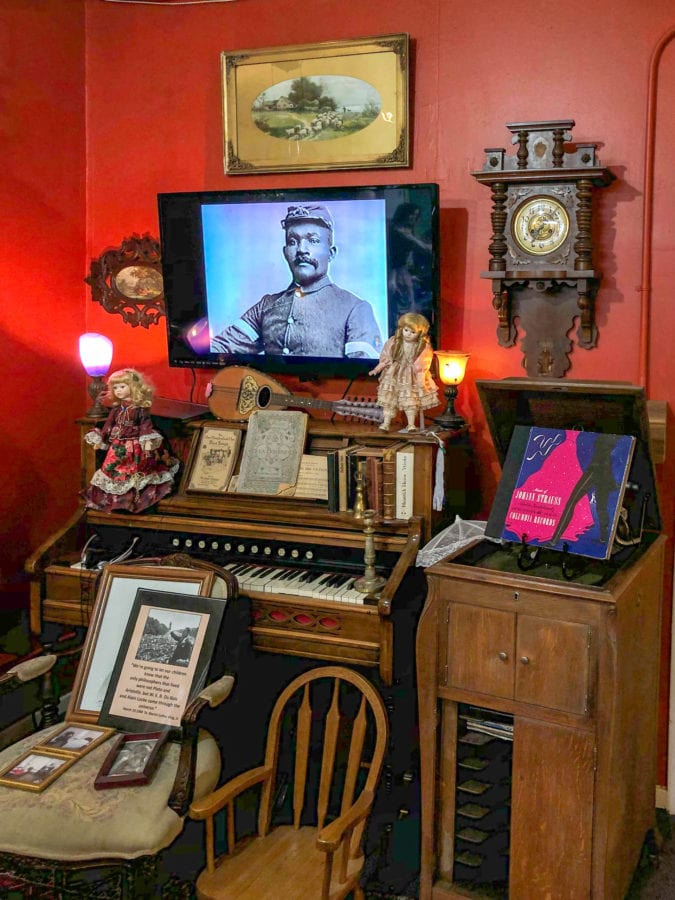 antique furniture and art including a piano, victrola, and clock
