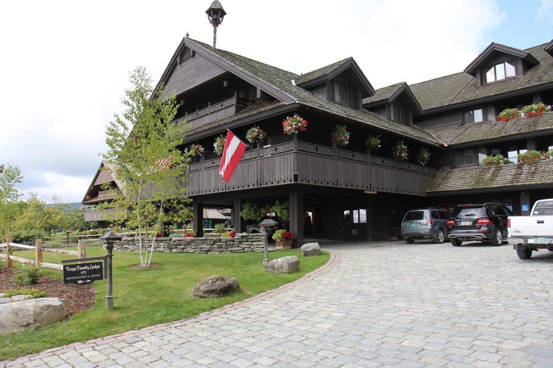A big Alpine-style lodge with cars parked in front