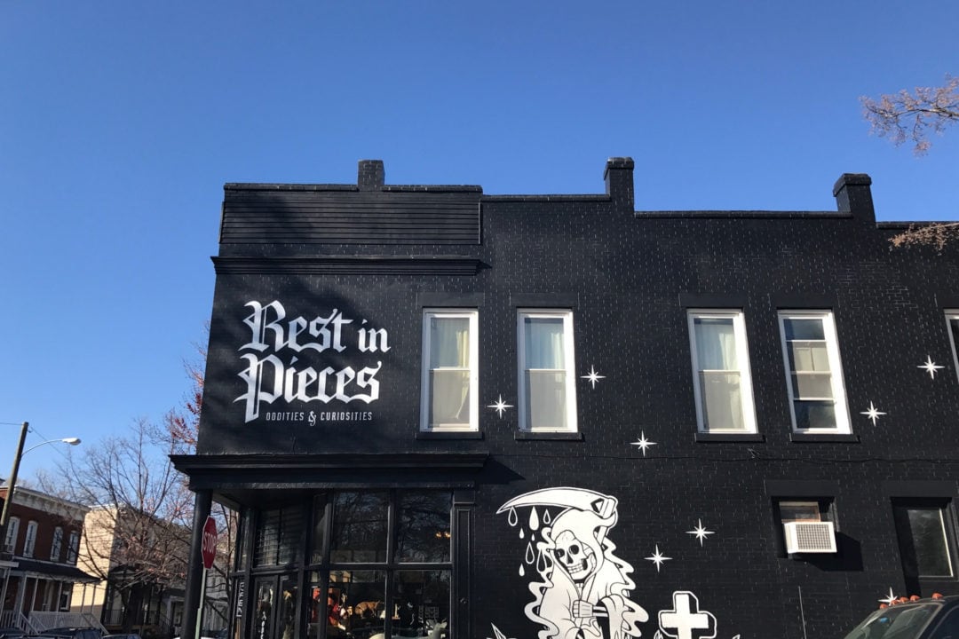 a black building with white lettering that says Rest in Pieces oddities and curiosities