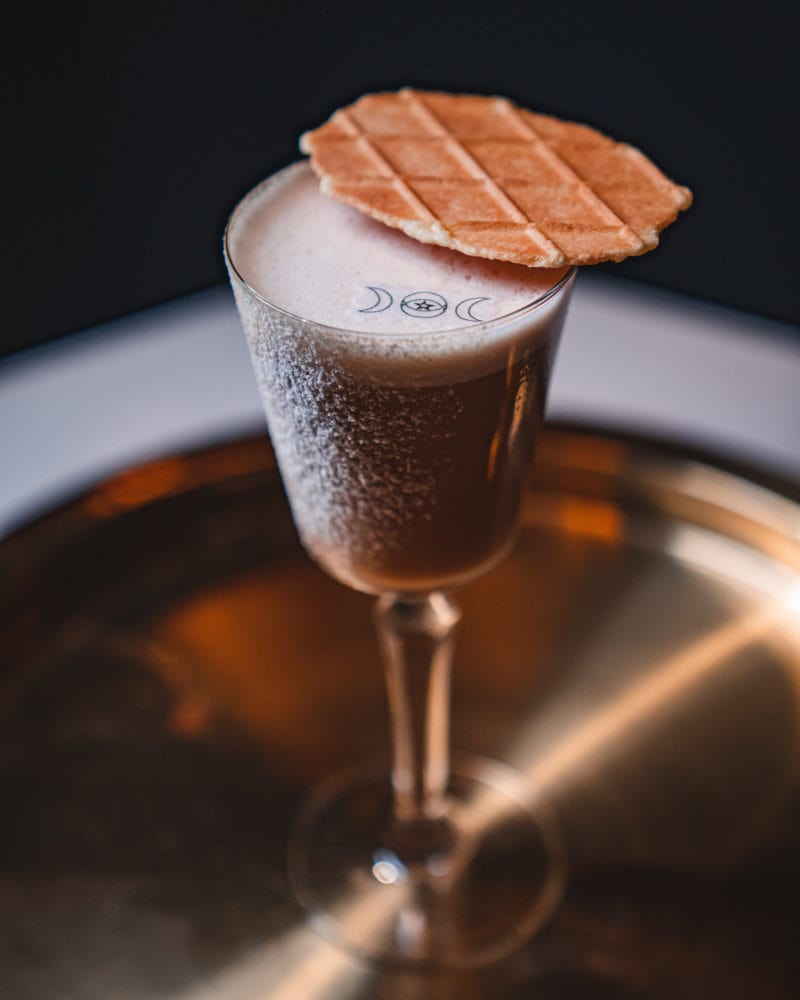 Craft cocktail topped with a wafer cookie