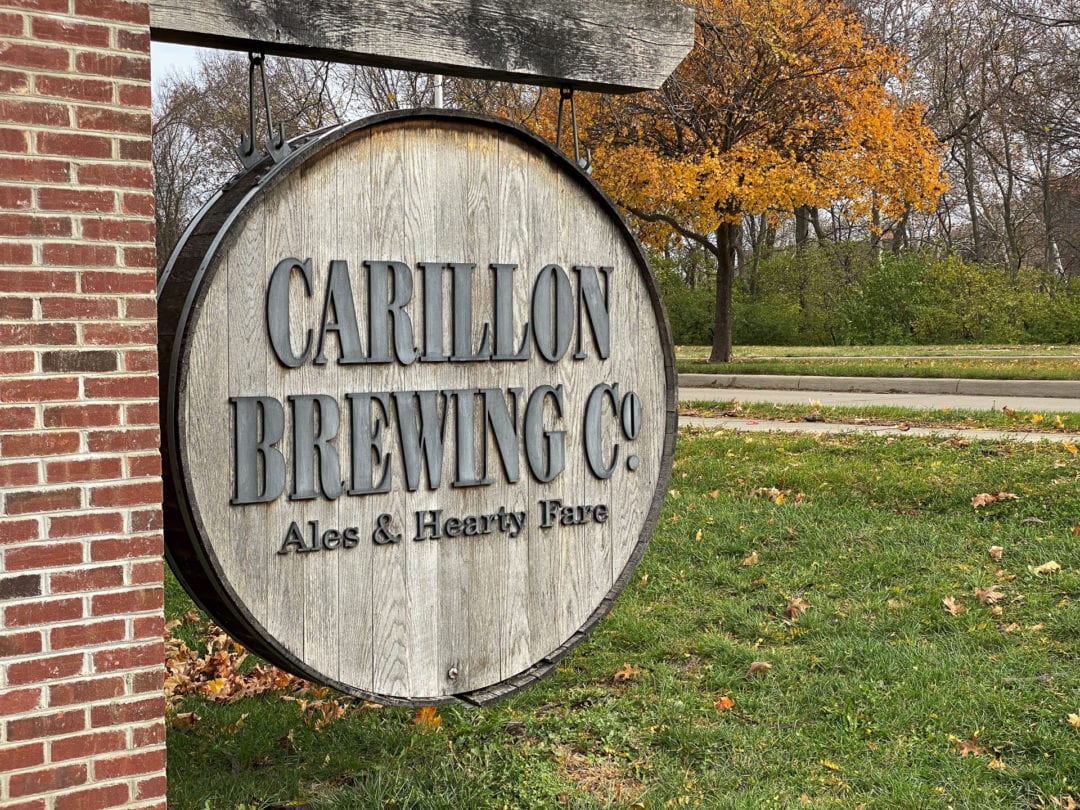 A sign made from a barrel top at the outdoor entrance for Carillon Brewing Co.