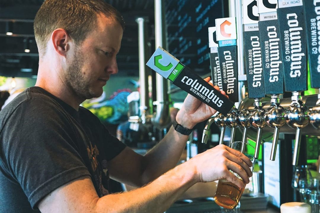 a man pours a beer from one of several taps