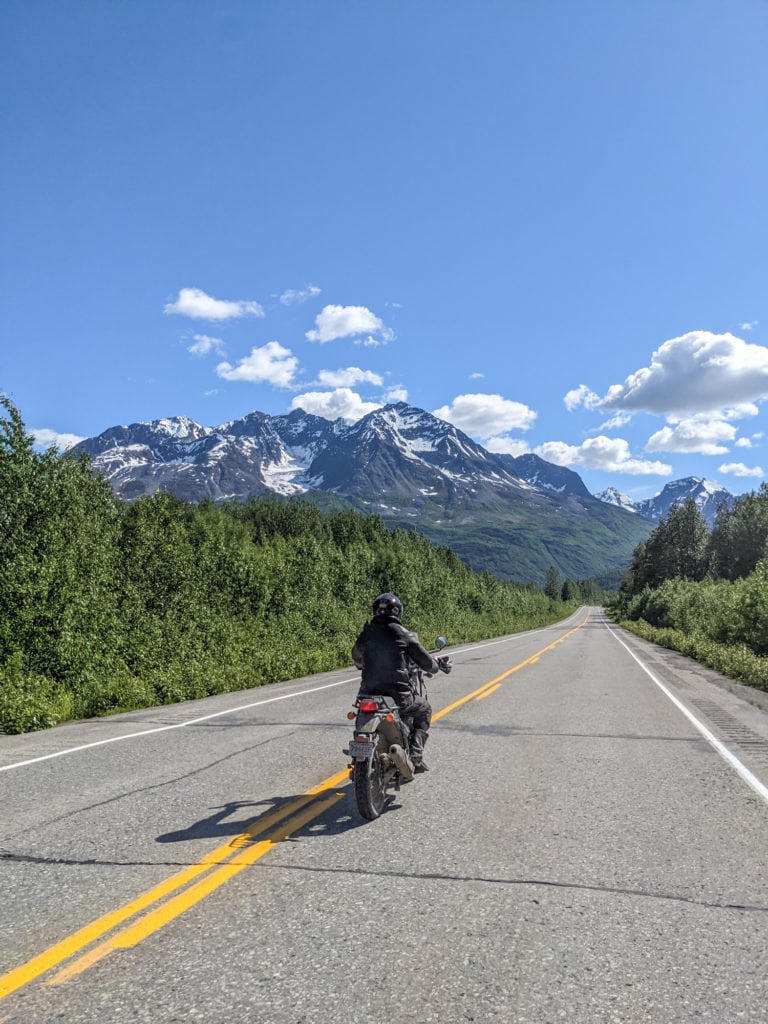 A person riding a motorcycle on an empty road