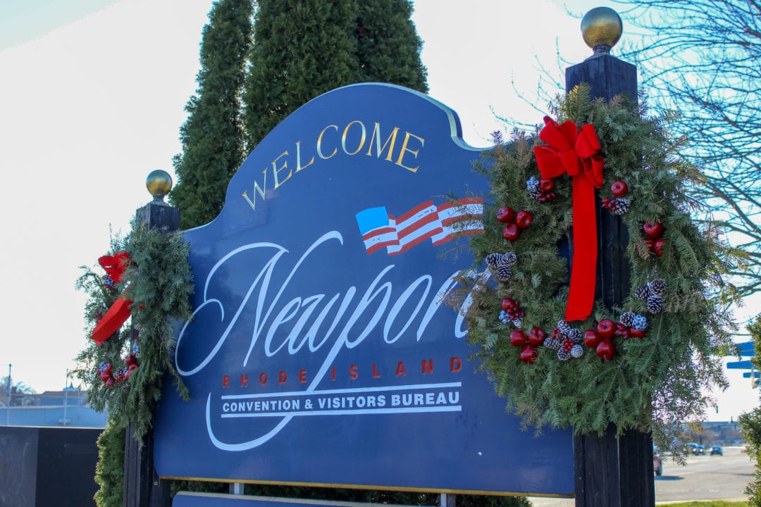 A welcome sign in Newport, Rhode Island with wreaths and red bows