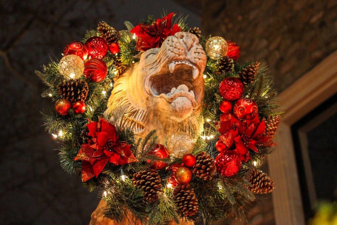 A holiday wreath with a roaring lion's head in the center