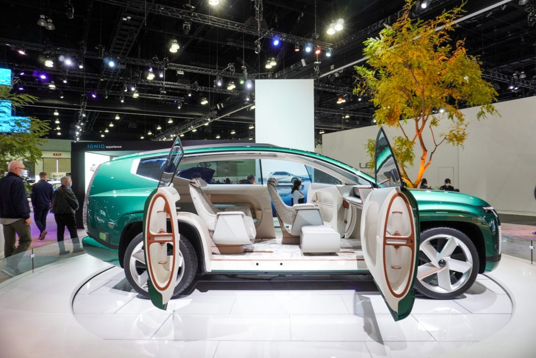 A green SUV with its doors open, and a spacious, all-white interior