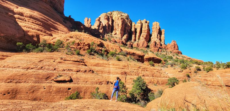 Woman looking up to red rock formations in Sedona, Arizona.
