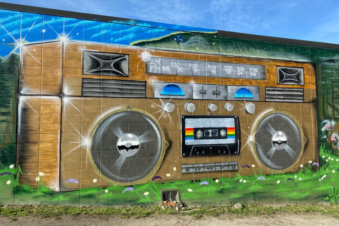 a mural of a boom box painted on a brick wall