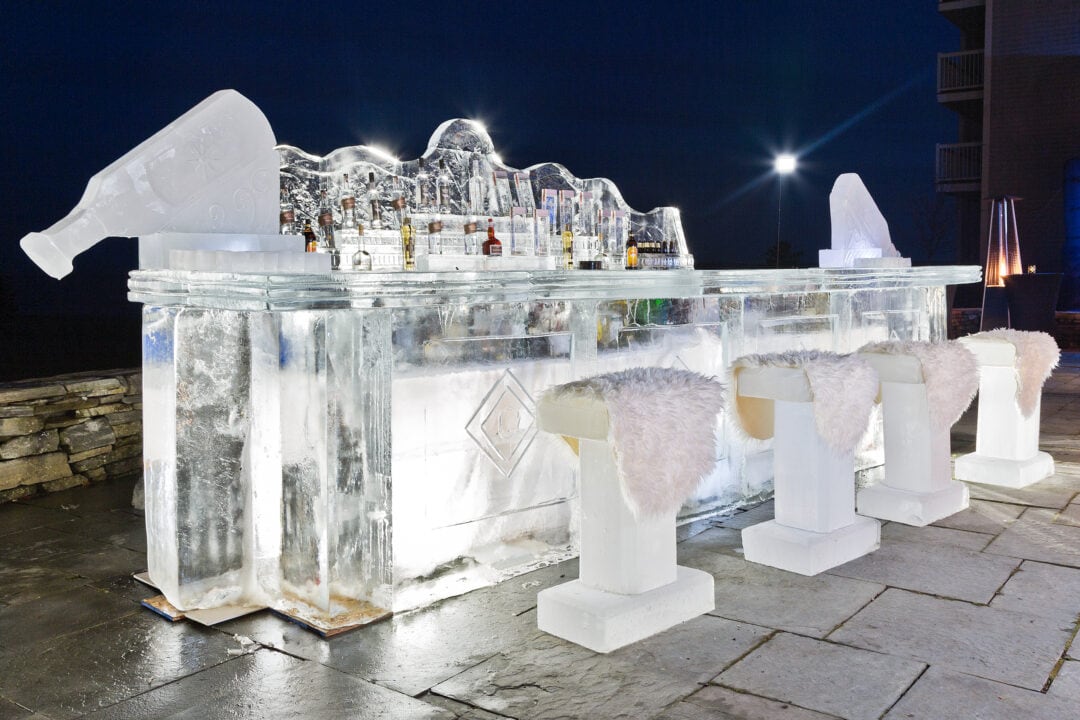 a bar and stool made of ice sits outside