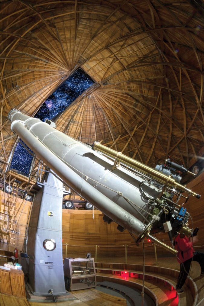 a very large telescope is pointed at the night sky under the dome of an obersvatory