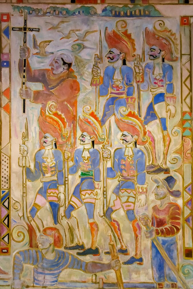 a colorful painted mural depicting several figures including one rowing a boat