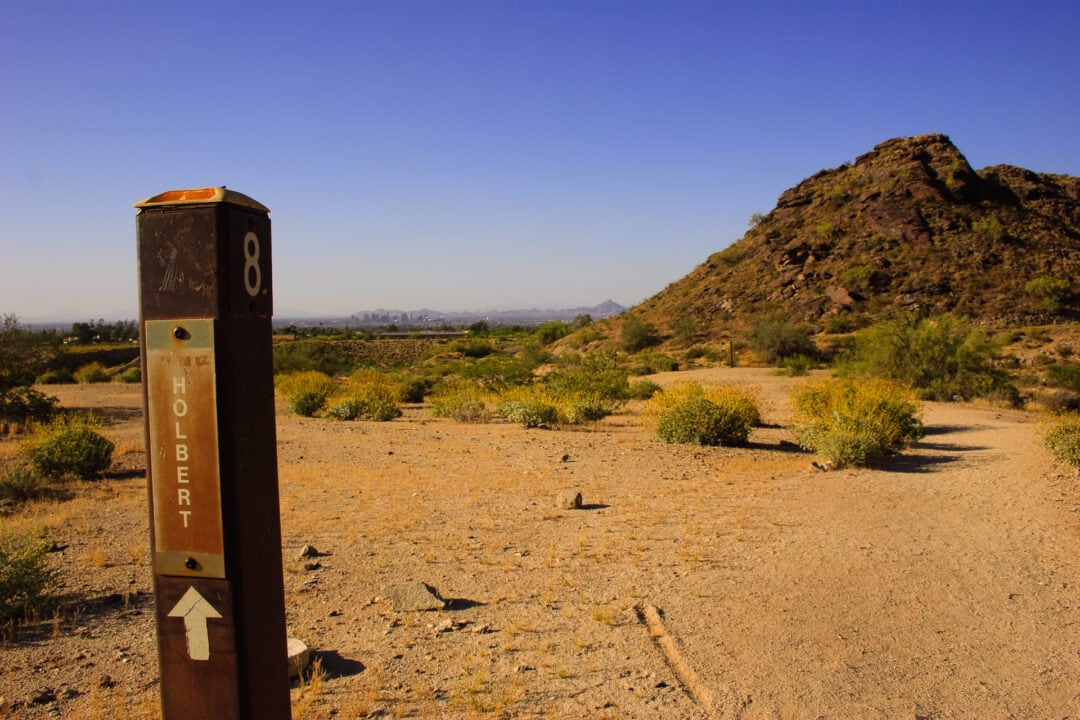 A view of downtown Phoenix in the distance at Holbert trail marker along the trail in South Mountain Park in Phoenix, Arizona.