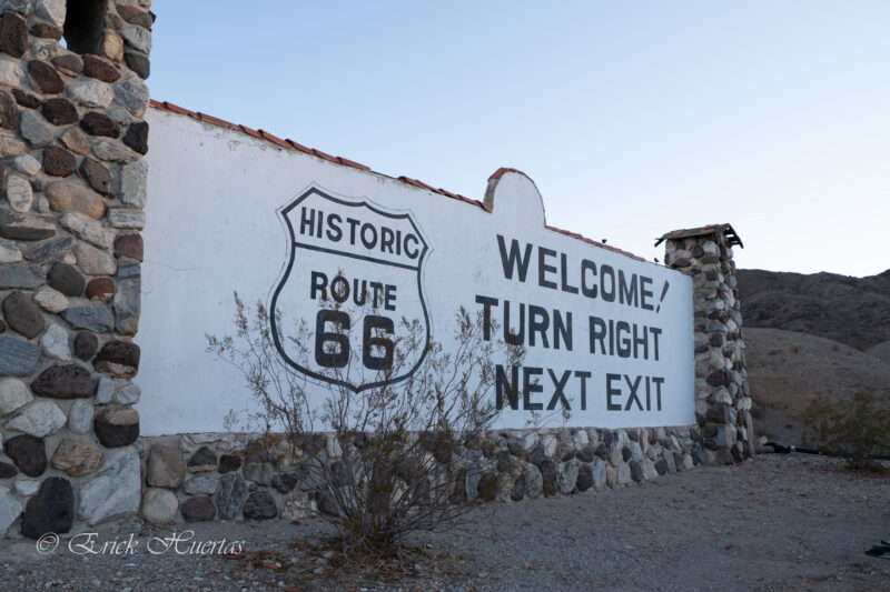 a black and white sign for route 66 that reads "welcome! turn right next exit"