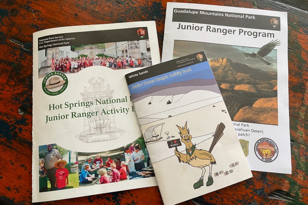 Three Junior Ranger booklets from several national parks spread out on a table