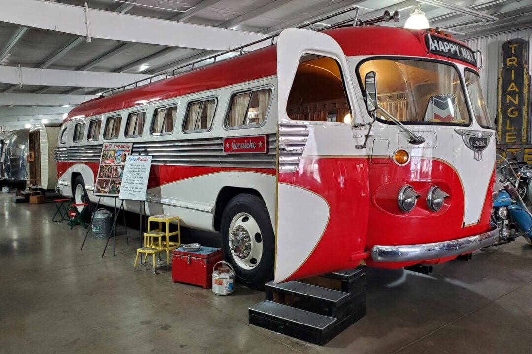 a red and white vintage bus on display in a museum