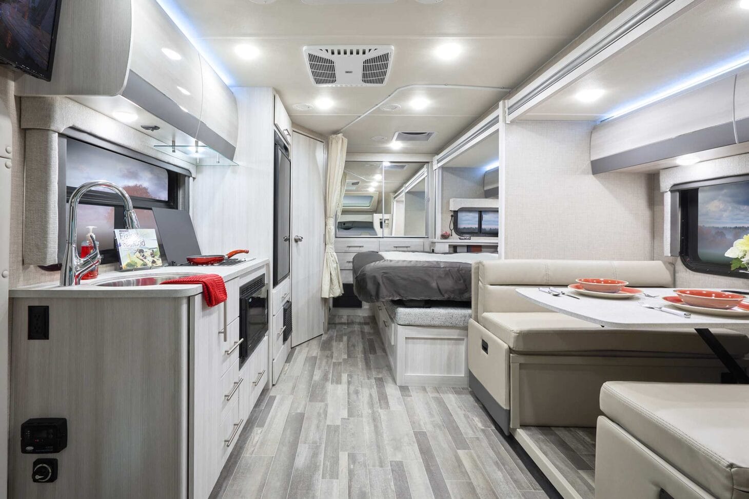 Interior of a large Class B+ RV with a kitchen, sleeping, and dining space