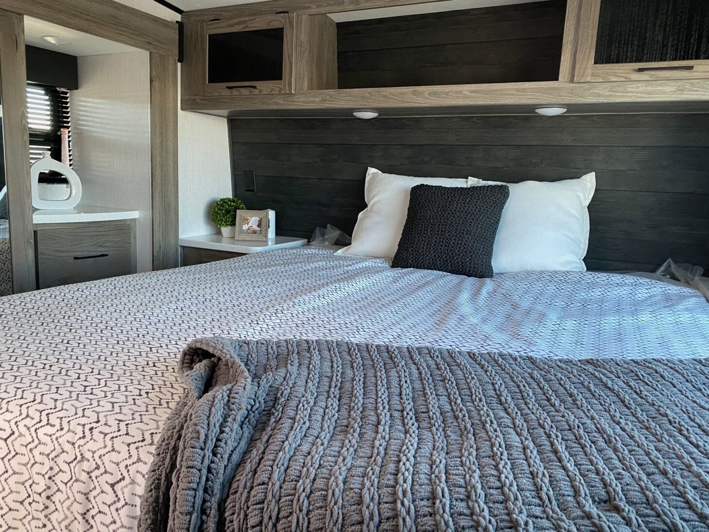 Bedroom in an RV with storage space above the bed
