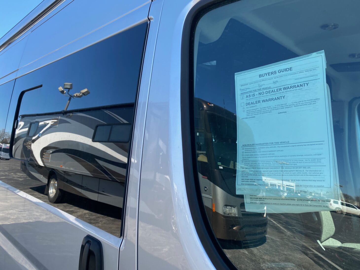 Dealer warranty terms posted on an RV window at a dealership.