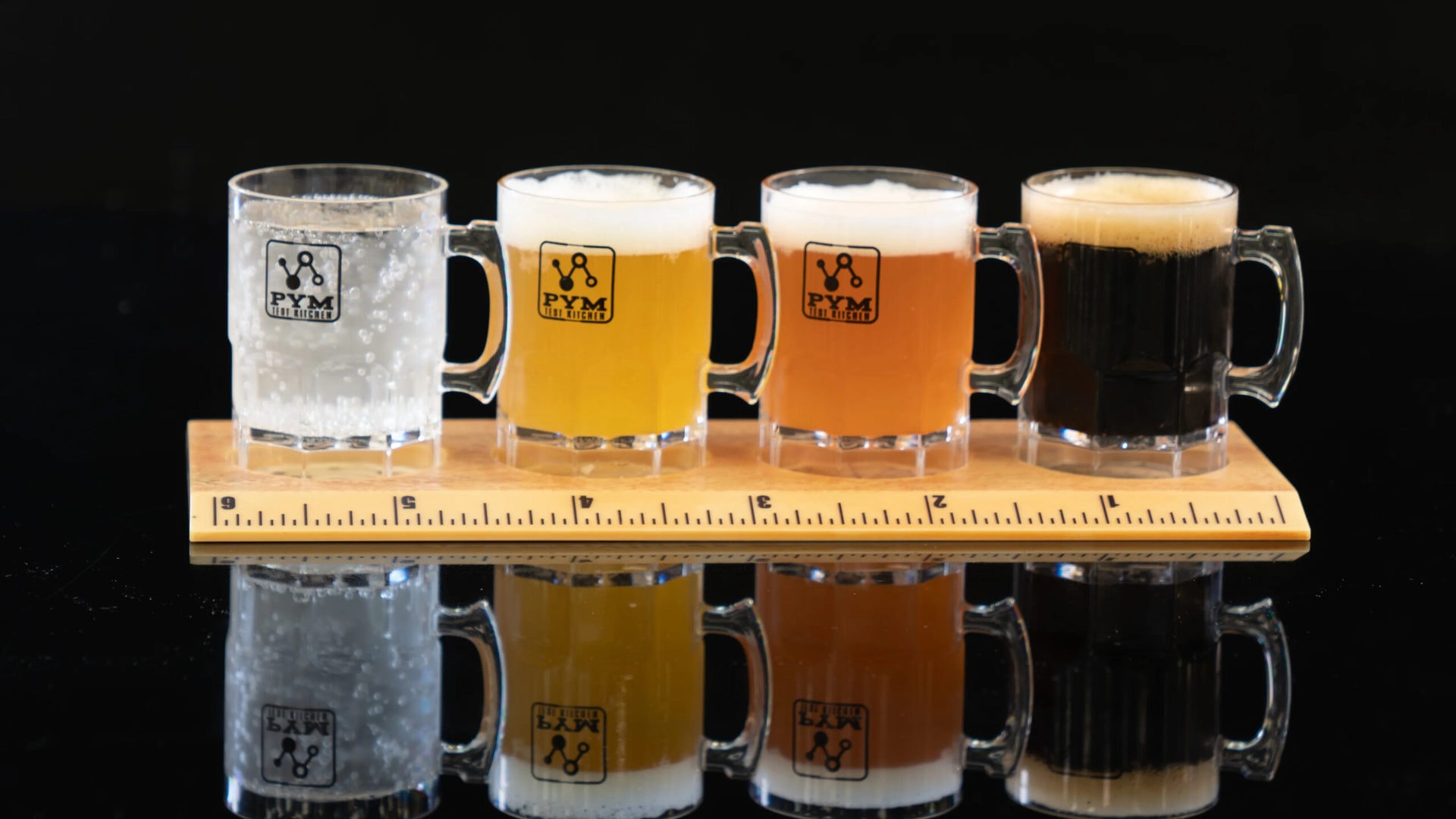 Tiny beer steins sitting on an over-sized ruler