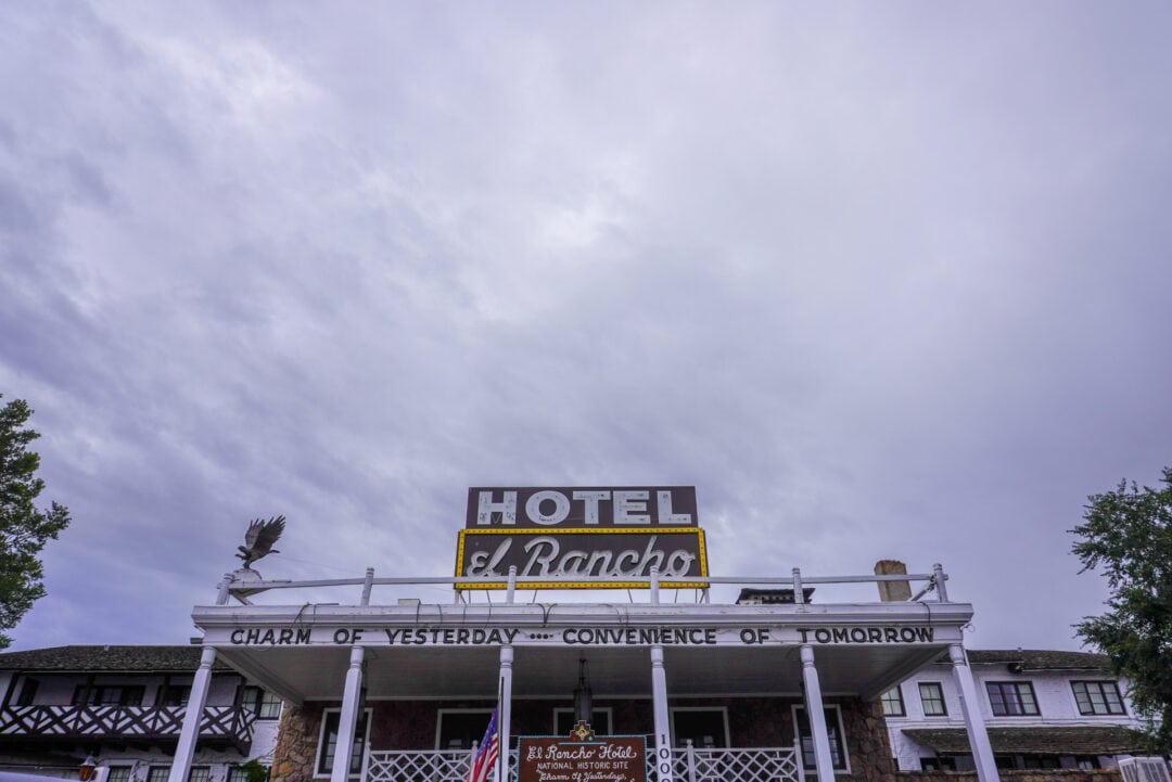 A Hotel el Rancho sign on top of a building set against a cloudy gray sky