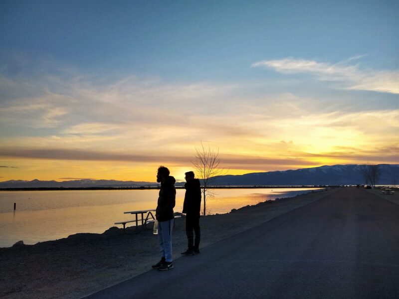 Two men standing on the shore of Utah Lake
