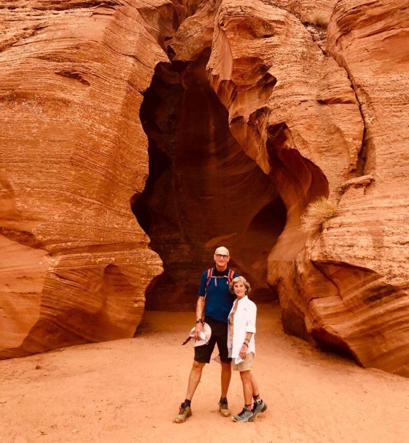 Two people standing in front of a red rock formation
