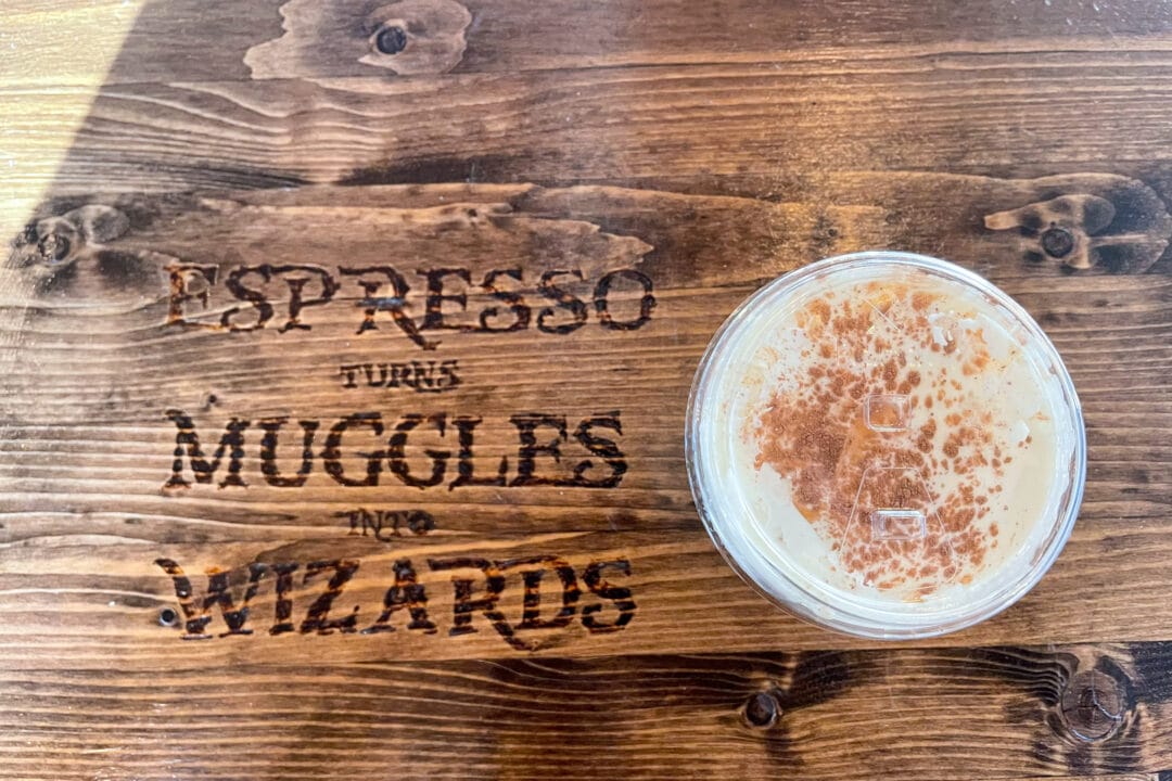 a wood table that says "espesso turns muggles into wizards" with a coffee drink