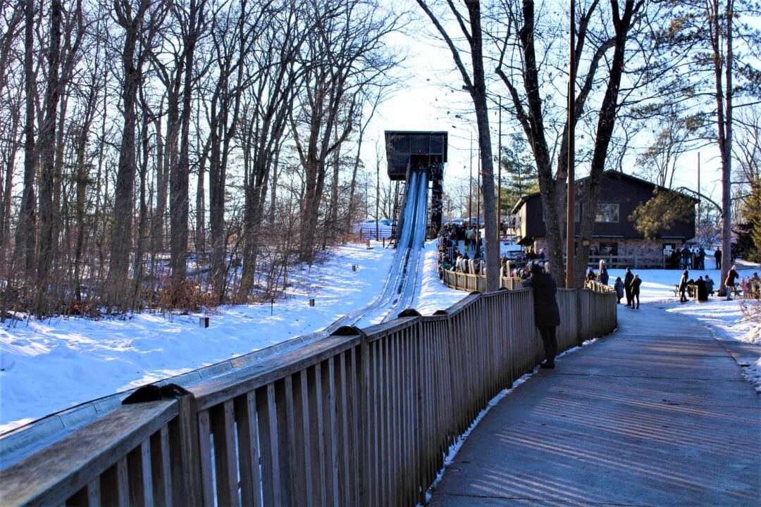 a toboggan run and wooden boardwalk in the snow