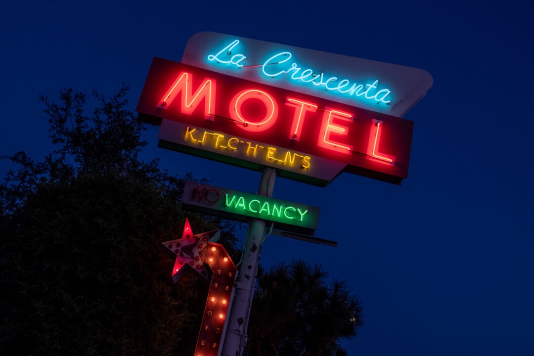 a neon sign lit up at night for the la crescenta motel