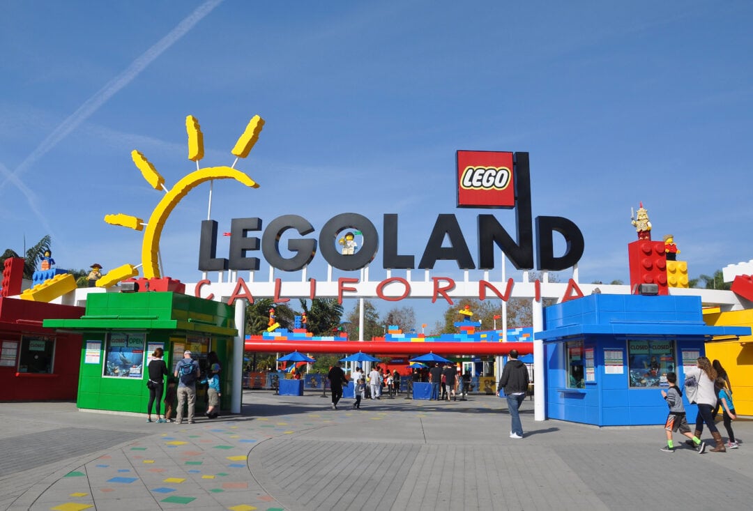 Entrance to LEGOLAND in California, featuring colorful signs and booths 