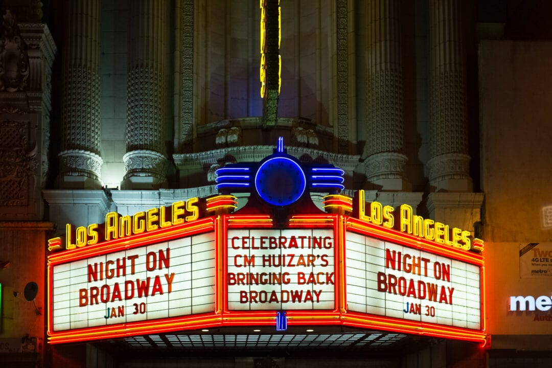 a neon marquee illuminated at night for the los angeles theatre