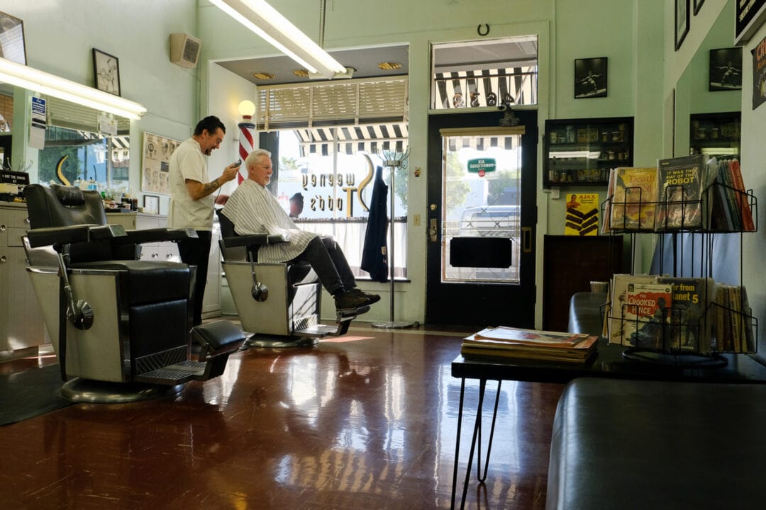 a man gets his hair cut at a barbershop