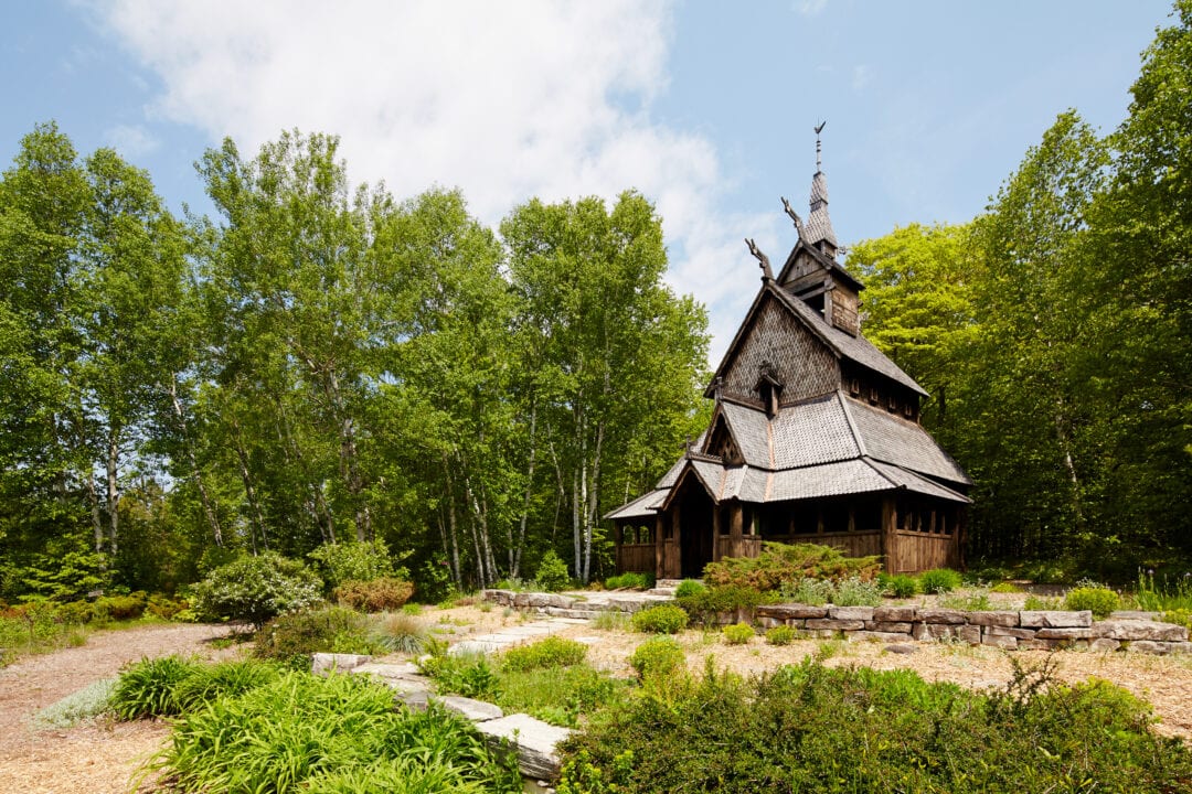 an elaborate stavkirke structure surrounded by greenery