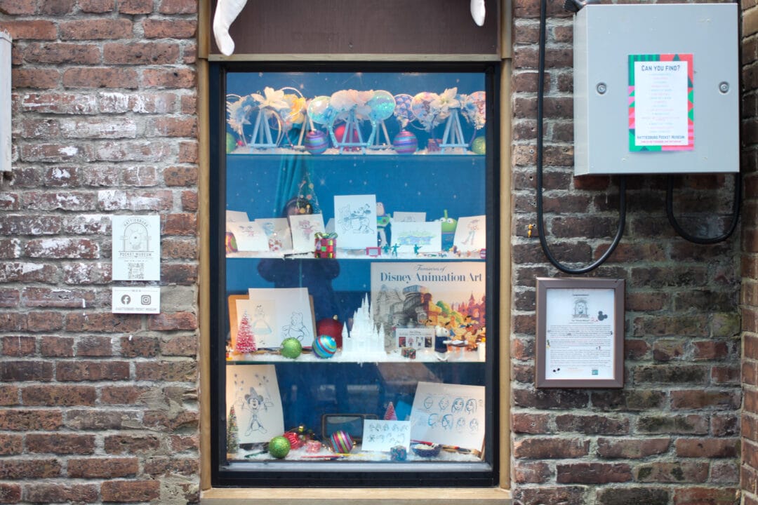 a window in the side of a brick building has shelves with drawings and christmas ornaments