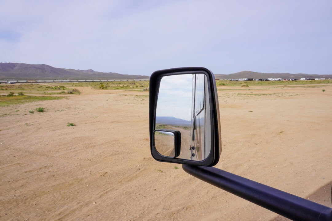 A view of the desert through an RV side mirror