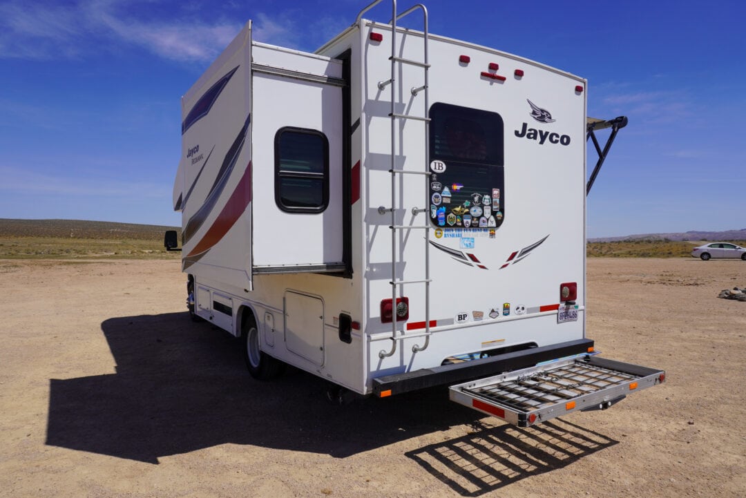 Class C motorhome with a bike rack in the rear and open slides