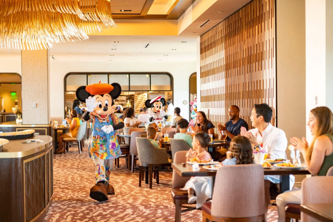 mickey and minnie mouse visit with guests at a restaurant