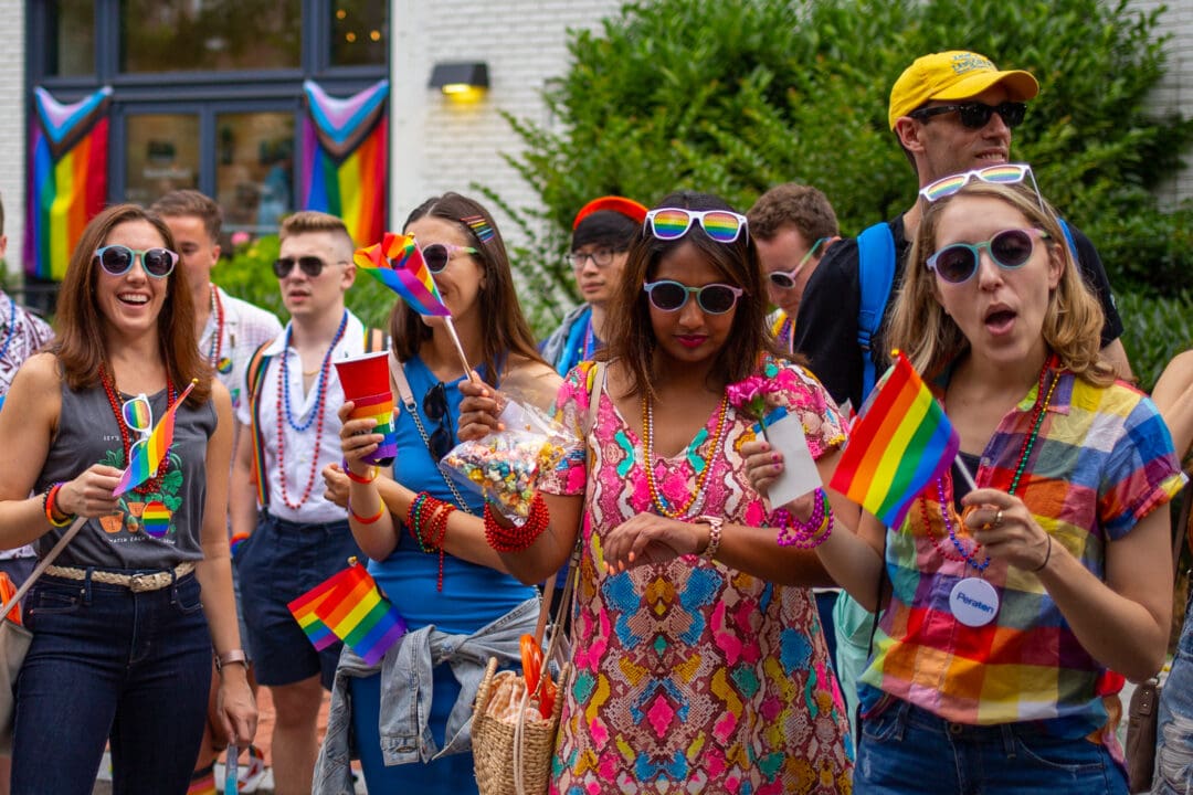 a crowd of colorful spectators watches a pride parade