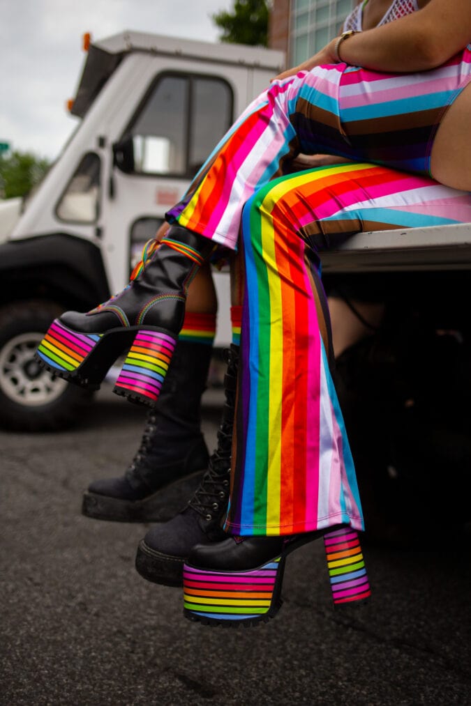 a pair of striped pants and platform boots bear the pride flag