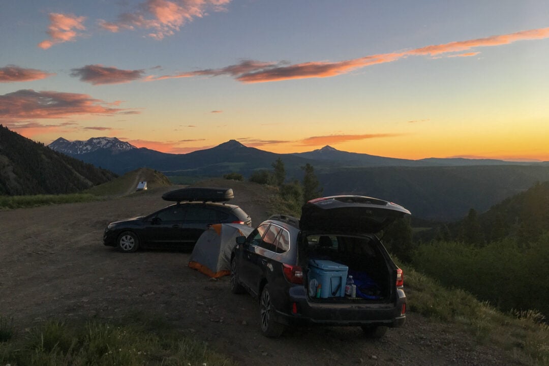 two cars are parked on a scenic mountain overlook next to a popped tent