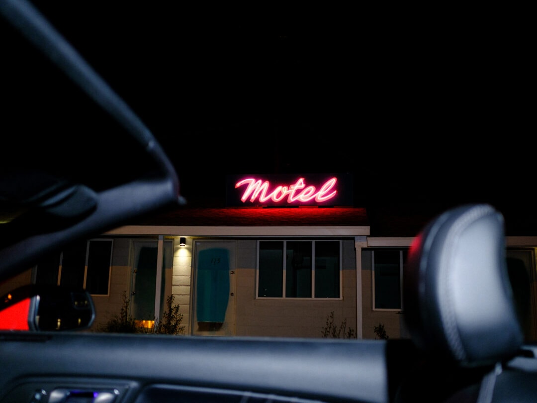 a motel at night with a red neon sign that spells out "motel" in script