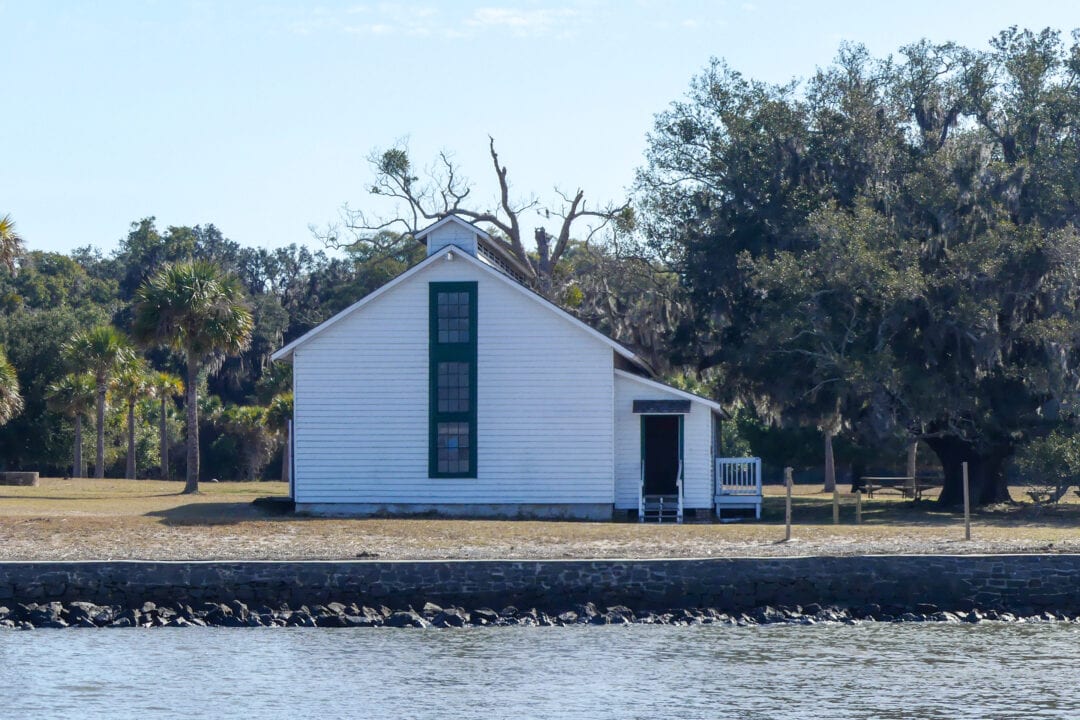 a small white building near the water's edge