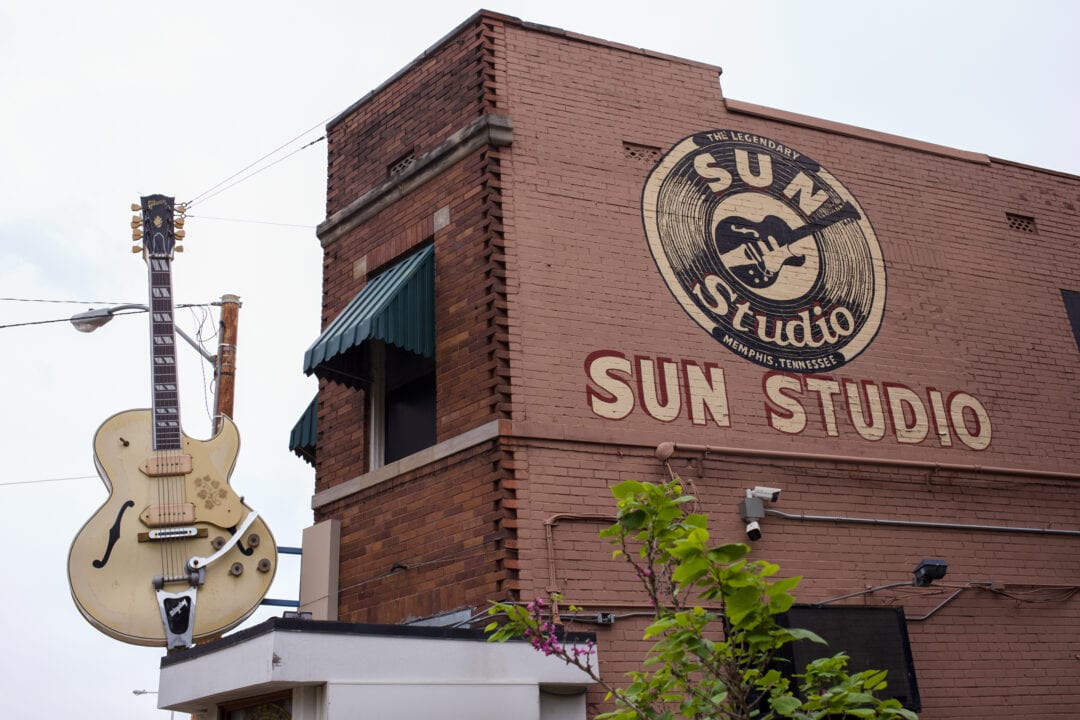 the brick exterior of sun studio with a large guitar hanging off the brick facade
